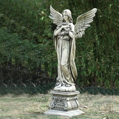 Angel holding wreath garden statue